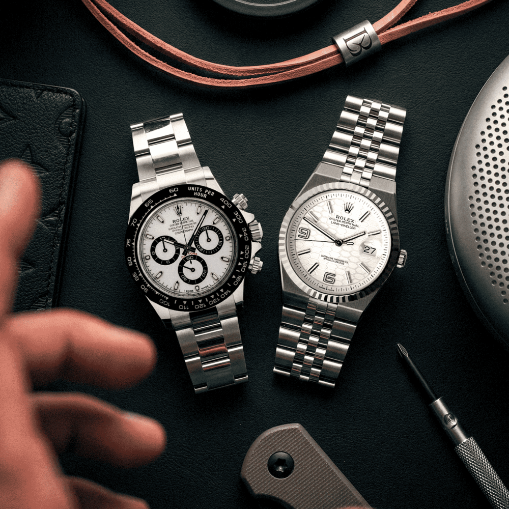 Rolex Daytona "Panda" and Rolex Land-Dweller on a table