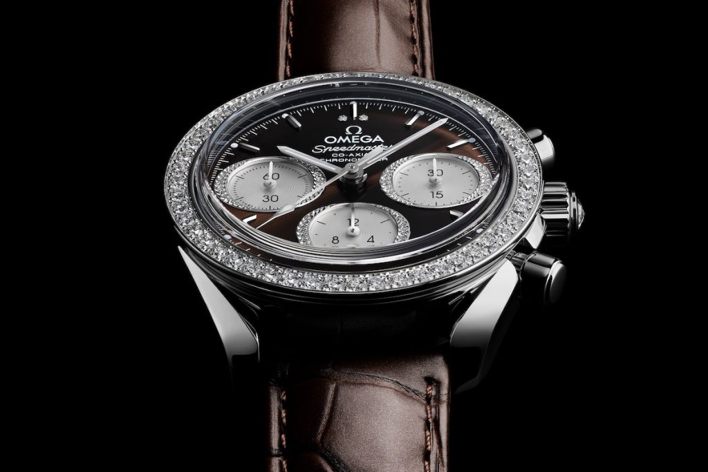 Steel and diamond Speedmaster 38 with a brown dial and strap