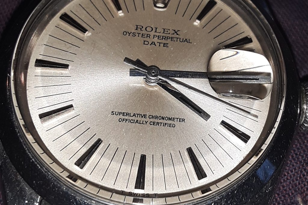 Black enamel-filled hands on a Rolex 1500 that says T Swiss T