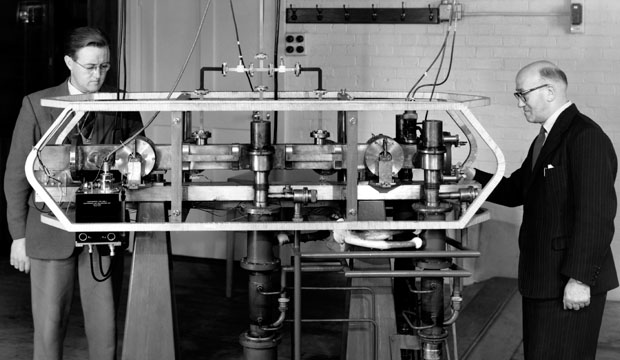 Jack Parry (left) and Louis Essen (right) next to the first cesium-133 atomic clock in 1955 at the National Physical Laboratory, England.