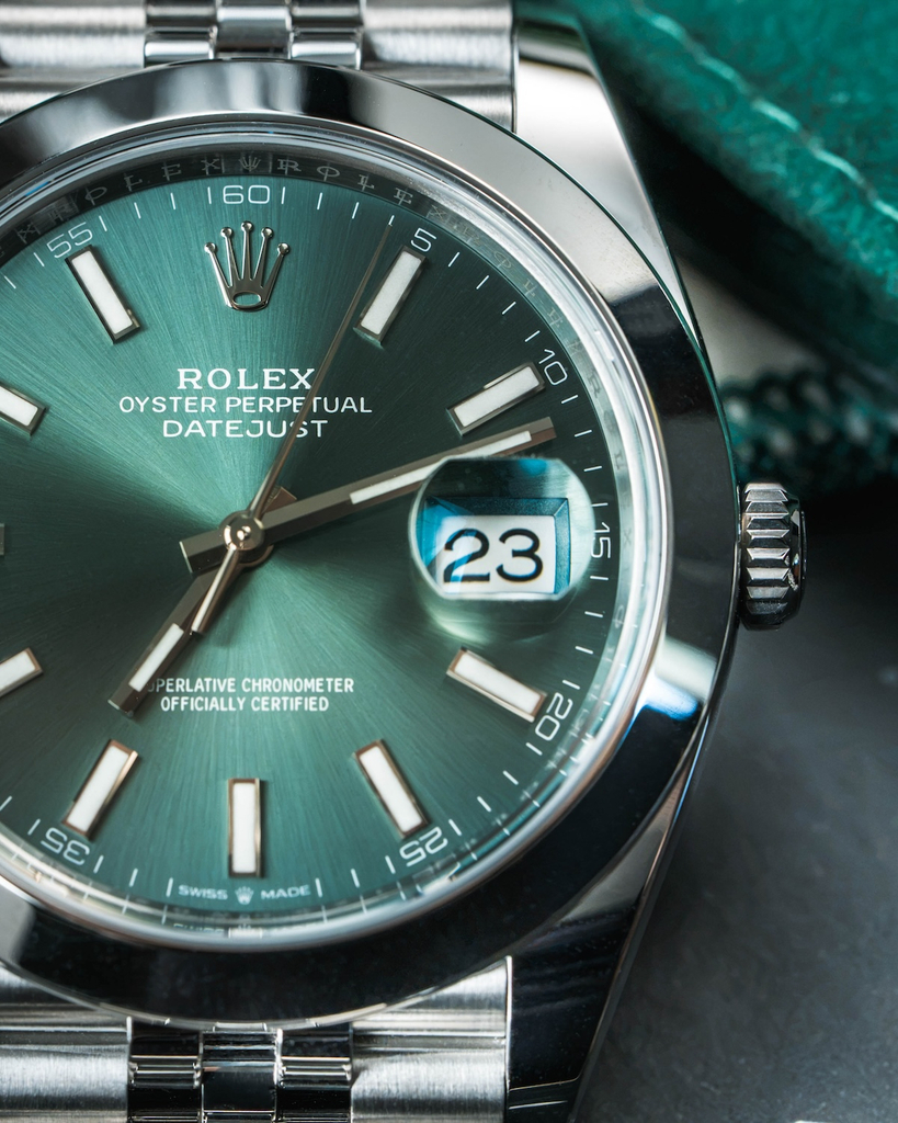 Rolex Datejust with a green dial showing the Cyclops lens magnifying the date window at 3 o'clock.