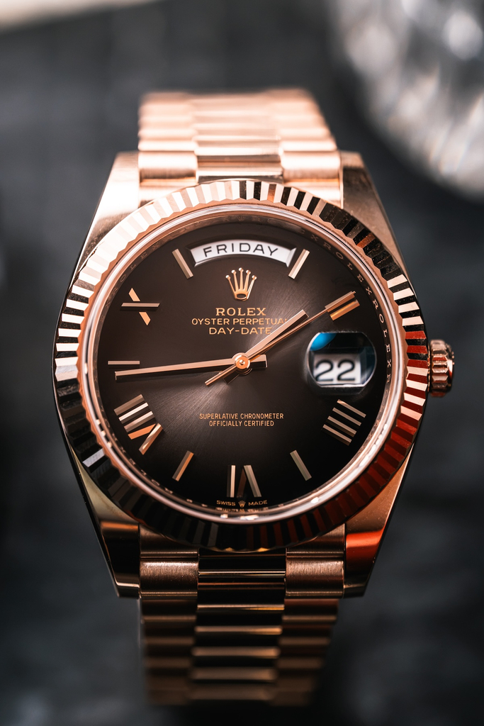 Rolex Day-Date 40 in Everose gold with a slate ombré dial, showing the Cyclops magnifying lens over the date at 3 o'clock.